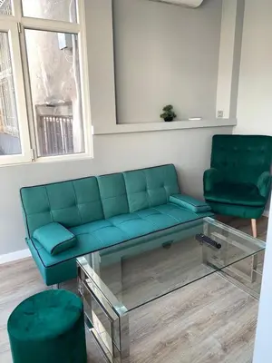 a living room with a blue couch and two green chairs at CENTER APARTMENT PLOVDIV in Plovdiv