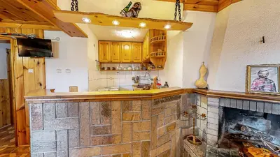 a kitchen with a stone fireplace in a room at Къща за гости Каневи in Momchilovtsi