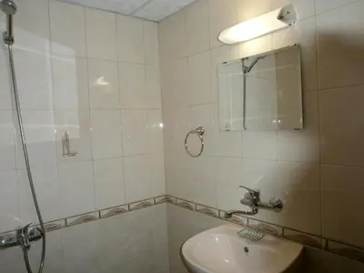 a bathroom with a shower and a sink and a mirror at Къща за гости Каневи in Momchilovtsi