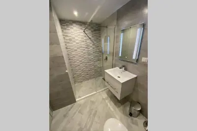 a bathroom with a white sink and a shower at LUX 1BD/1BA City Center Apartment in Blagoevgrad