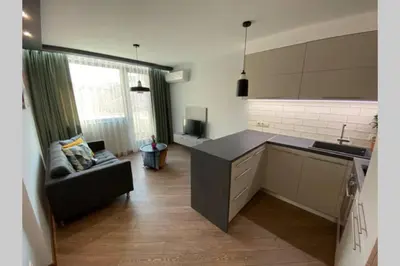 a kitchen with a couch and a table in a room at LUX 1BD/1BA City Center Apartment in Blagoevgrad