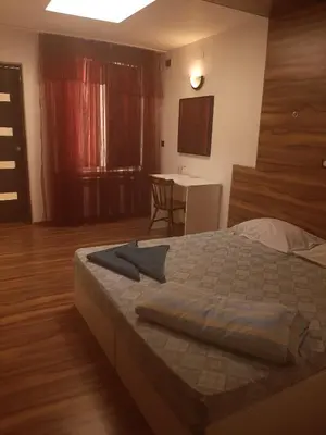 a bedroom with a bed and a table with a chair at Hostel Pop Bogomil in Sofia