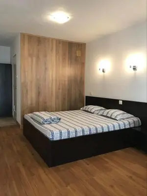 a bedroom with a large bed with a wooden wall at Hostel Pop Bogomil in Sofia