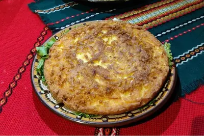 a pie sitting on a plate on a table at Къща за гости Динас in Zmeitsa