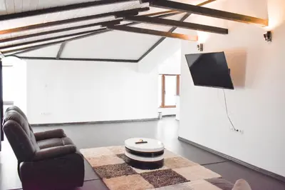 a living room with a chair and a tv at Casafamiglia in Prolesha