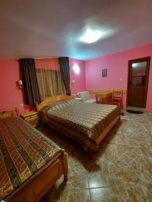a hotel room with two beds and pink walls at Вила Сладък Живот in Tsigov Chark