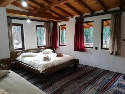 a bedroom with two beds in a room with windows at GUEST HOUSE ELENA in Kosovo