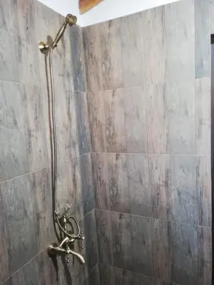 a shower with a hose in a bathroom at GUEST HOUSE ELENA in Kosovo