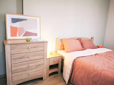 a bedroom with a bed and a dresser with a picture at So Close Kapana - 2 Rooms Central Apartments in Plovdiv