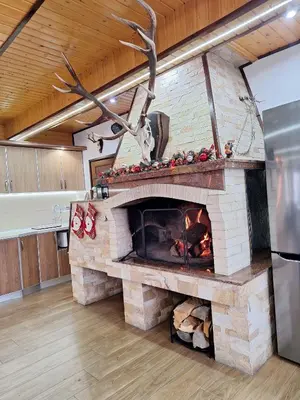 a living room with a stone fireplace in a house at Perla in Dospat