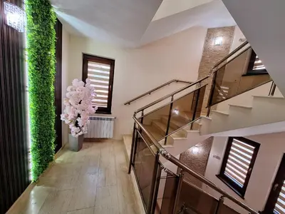 a hallway with stairs and a vase of flowers at Perla in Dospat