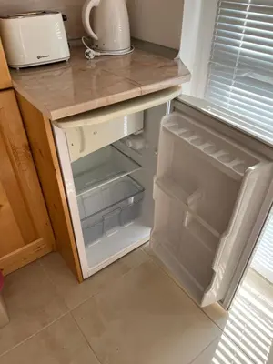 an empty refrigerator with its door open in a kitchen at Iglika 2 - Studio Cabin in Borovets