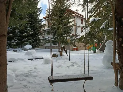 a swing in the snow next to a snow man at 