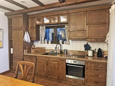 a kitchen with wooden cabinets and a sink at Stoykite-Pamporovo Nature Retreat in Stoykite