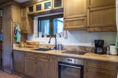 a kitchen with wooden cabinets and a sink at Stoykite-Pamporovo Nature Retreat in Stoykite