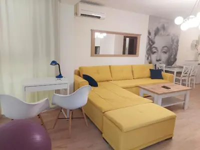 a living room with a yellow couch and a table at Sandanski Apartments Top Center in Sandanski