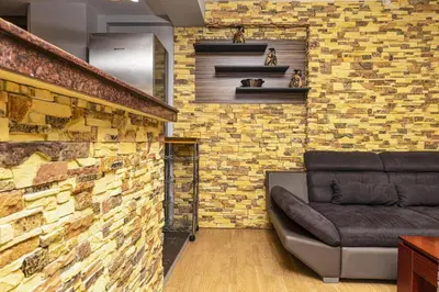a living room with a couch against a brick wall at 1BD Apartment - 5 mins to the city centre by Flat Mаnager in Plovdiv