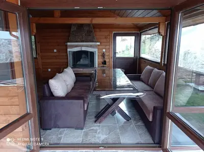 a living room with a couch and a fireplace at Вила Хоризонт in Tsigov Chark