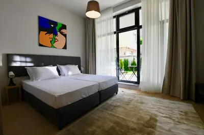 a bedroom with a bed and a large window at Connect Living Apartments in Sofia