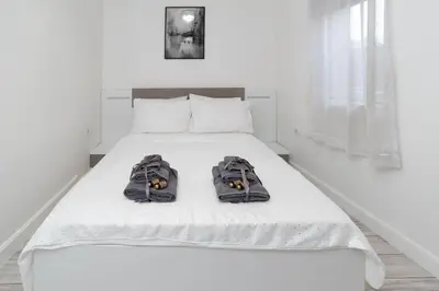 a white bed with two pairs of shoes on it at Beautiful Place in The Heart of The City!!!! in Plovdiv