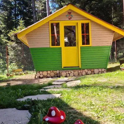 a small house with a yellow door in a yard at Вила Пенчеви, кк. Цигов чарк in Tsigov Chark