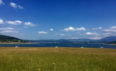 a field of grass with a large body of water at Вила Пенчеви, кк. Цигов чарк in Tsigov Chark