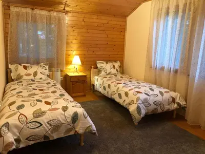 a bedroom with two beds in a log cabin at Вила Пенчеви, кк. Цигов чарк in Tsigov Chark