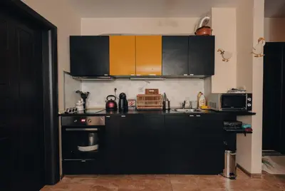 a kitchen with black cabinets and a stove at Max Holiday Apartment in Pamporovo