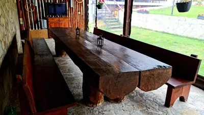 a large wooden table in front of a window at ПАУНОВАТА КЪЩА in Yasă-Koriya