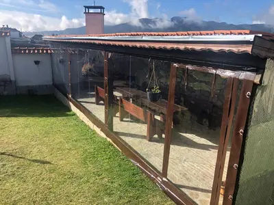 a covered patio with a table and a bench at ПАУНОВАТА КЪЩА in Yasă-Koriya