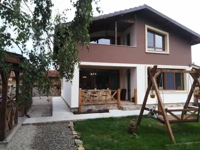 a house with a porch and a swing in the yard at Guest House Kalina in Sapareva Banya