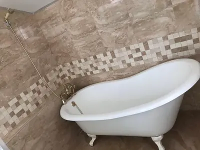 a white bath tub in a tiled bathroom at Guest House Kalina in Sapareva Banya