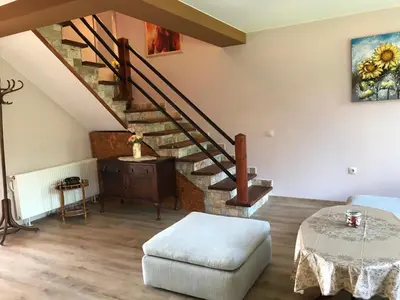 a living room with a staircase and a table at Guest House Kalina in Sapareva Banya