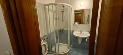 a bathroom with a shower and a toilet and a sink at Two bedroom flat in Magernitsa in Bansko