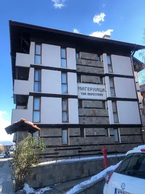 a building with a sign on the side of it at Two bedroom flat in Magernitsa in Bansko