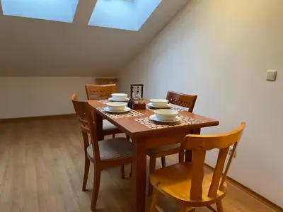 a dining room with a wooden table and chairs at Two bedroom flat in Magernitsa in Bansko