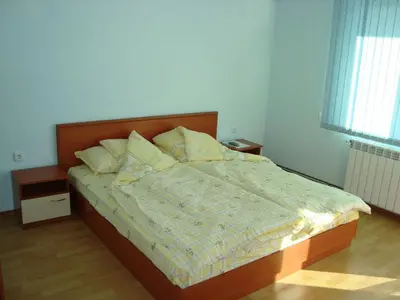 a bedroom with a large bed with a wooden headboard at Хотелски Комплекс Авалон in Asenovgrad