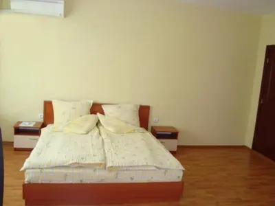 a bedroom with a bed with two night stands at Хотелски Комплекс Авалон in Asenovgrad