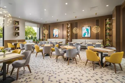 a dining room with tables and chairs in a restaurant at Hotel Jägerhof in Plovdiv