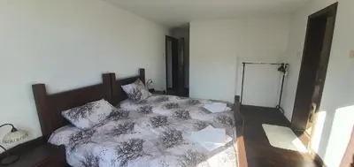 a bedroom with a bed with a comforter and pillows at Guest House Ela in Dolna Banya