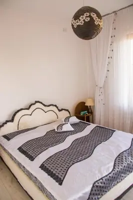 a bedroom with a bed with a black and white blanket at вила Топи in Kaloyanovo