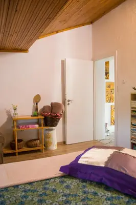 a bedroom with a bed and a door and a table at вила Топи in Kaloyanovo