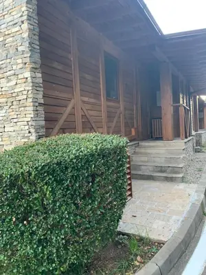 a house with a hedge in front of a building at Katarino Mountain House in Razlog
