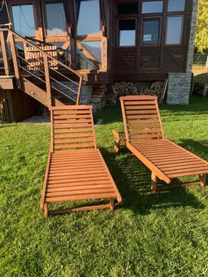 two wooden chairs sitting in the grass in front of a cabin at Katarino Mountain House in Razlog