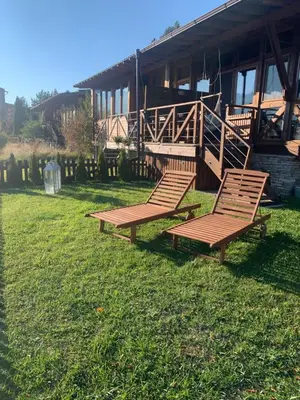 two benches sitting in the grass in front of a building at Katarino Mountain House in Razlog