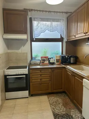 a kitchen with a stove and a window with a fishtank at Didi Park House къща с две спални in Sandanski