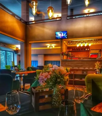 a restaurant with a table with a vase of flowers at Вила АРБОРЕТУМ - онлайн self check-in in Teteven