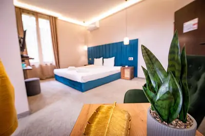 a hotel room with a bed and a table with a plant at Вила АРБОРЕТУМ - онлайн self check-in in Teteven