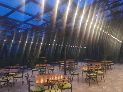 a room with tables and chairs and lights on the ceiling at Вила АРБОРЕТУМ - онлайн self check-in in Teteven
