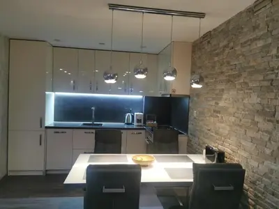 a kitchen with a table and a brick wall at Paradise Swing Apartment Sofia in Sofia